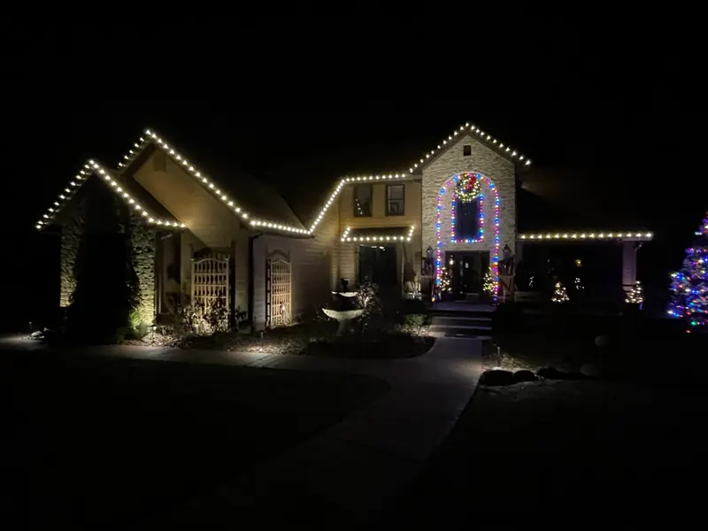 White and multicolor Christmas light display on a family home